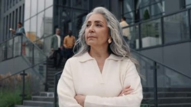 Charming aged business lady posing with crossed arms