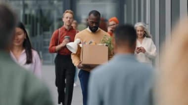 African american man carrying box with office stuff outdoors
