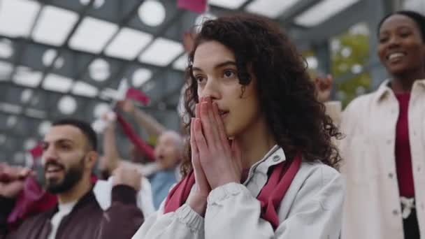 Young woman watching soccer match on stadium — Stockvideo