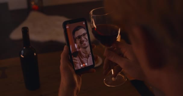 Man drinking red wine with his boyfriend during video call — Stok video