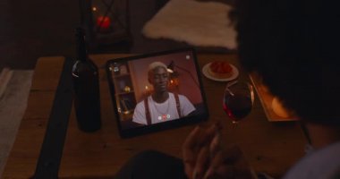 African couple waving hands and smiling during video call