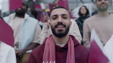 Arabian bearded man smiling on camera during soccer game