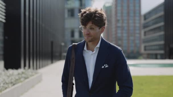 Hombre de negocios guapo usando teléfono inteligente mientras camina — Vídeos de Stock