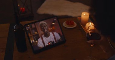 African american couple chatting and drinking during video call