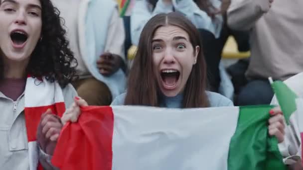 Female fan waving with italian flag during football match — Stockvideo
