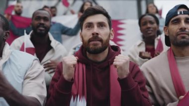 Futbol maçında takımın başarısızlığını izleyen hayal kırıklığına uğramış bir adam.