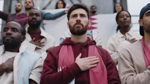 Hombre con la mano en el corazón escuchando himno durante el partido de fútbol — Vídeo de stock