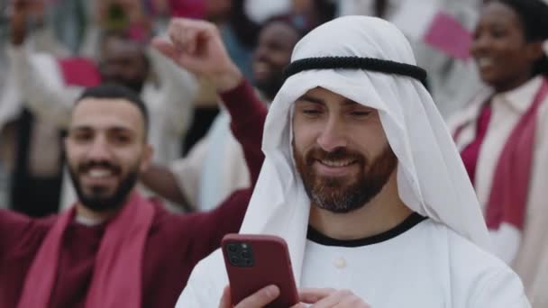 Arabski Sheikh za pomocą telefonu komórkowego do nagrywania piłki nożnej gry — Wideo stockowe