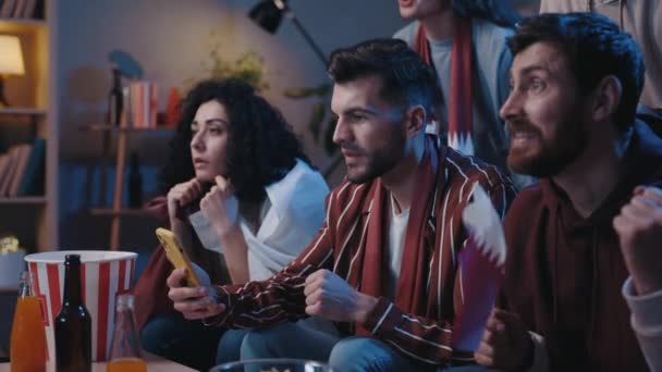 Spännande manliga innehav smartphone och titta på skärmen från tid till annan samtidigt kontrollera priser. Glad man med Qatar flagga firar och skriker nära sin glada vän med glada känslor. — Stockvideo