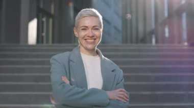 Açık havada kısa saçlı, gülümseyen iş kadını.