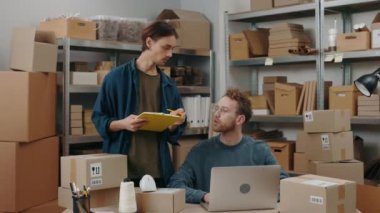 Kendine güveni tam bir adam elinde dosyayla ofiste dizüstü bilgisayarda çalışırken erkek arkadaşına bir şeyler anlatıyor. Küçük işletme kavramı.