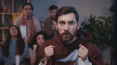 Gergin futbol taraftarı Katar bayrağı tutuyor ve evde oturup TV 'de yarışma izlerken heyecandan donakalıyor. Favori takımı destekleyen endişeli insanlar bir gol bekliyorlar..
