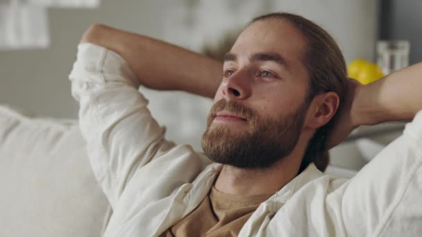 Entspannter Mann entspannt auf Couch mit den Händen hinter dem Kopf — Stockvideo