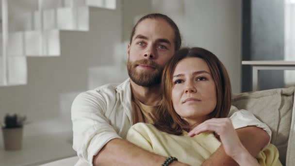 Dos personas amorosas sentadas en fuertes abrazos en un sofá acogedor — Vídeo de stock
