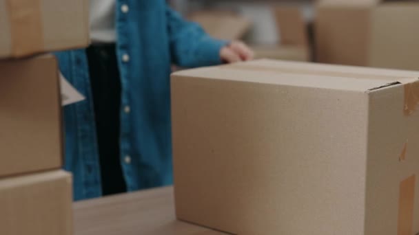 Känslig. Beskuren bild av den uppmärksamma asiatiska kvinnan sätta särskild dekal på skåpet paket låda när du arbetar på lagret. Post service och småföretag koncept. — Stockvideo