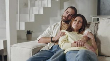 Rahat bir çift, rahat bir kanepede oturuyor.