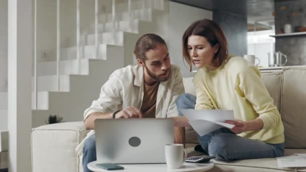 Casal focado usando laptop para fazer impostos em casa — Vídeo de Stock