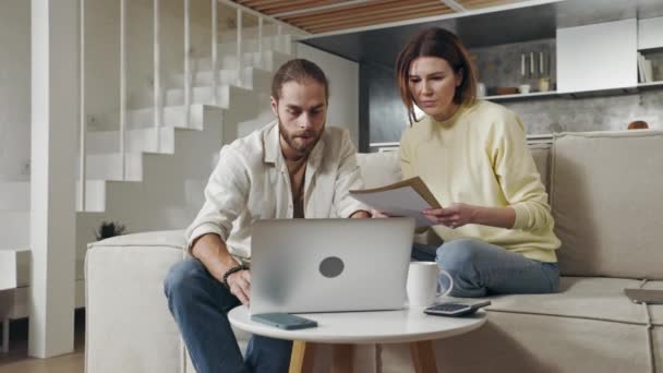 Familia en casa contando facturas en laptop — Vídeo de stock