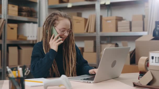 Özenli, beyaz tenli, gözlüklü bir kadın laptopun başında oturup merkez ofiste çalışırken klavyeye bir şeyler yazıyor. Posta servisi ve küçük işletme kavramı. — Stok video