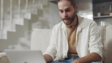 Sakallı adam evde video görüşmesi için dizüstü bilgisayar kullanıyor.