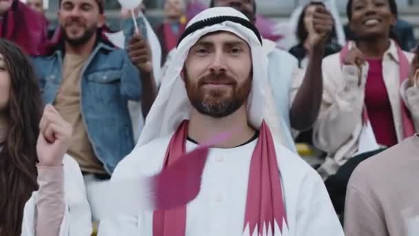 Sorrindo homem árabe aplaudindo durante o jogo de futebol — Vídeo de Stock
