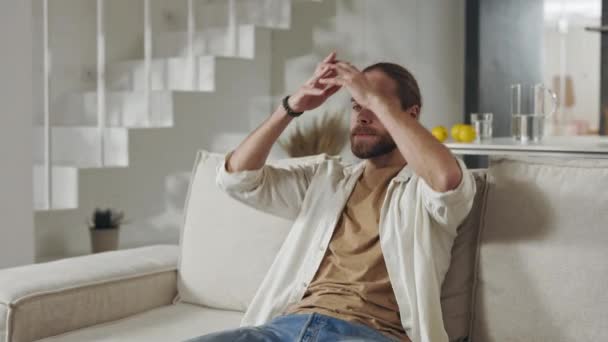 Schöner Mann ruht auf Couch mit Händen hinter dem Kopf — Stockvideo