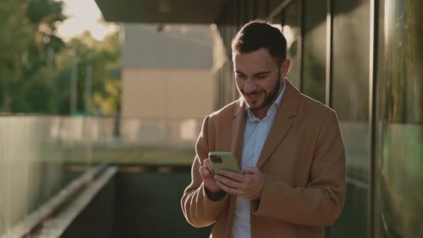 Щасливий бізнесмен отримує чудові новини на смартфоні — стокове відео