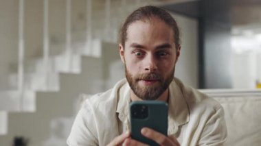 Heyecanlı adam cep telefonundan iyi haberler alırken mutlu oluyor.