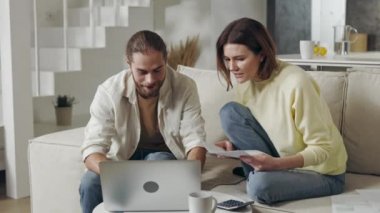 Harcamalarını hesaplamak için dizüstü bilgisayar kullanan odaklı çift.