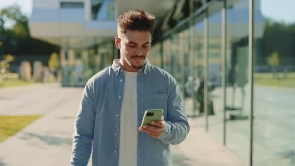 Hombre usando auriculares y móviles para escuchar música al aire libre — Vídeo de stock