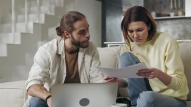 İki kişilik beyaz bir aile dizüstü bilgisayarla ev ekonomisini kontrol ediyor.