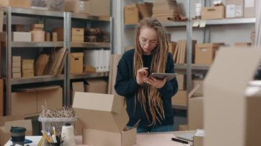 Beyaz kızın tablet bilgisayarı tutarken belindeki portre görüntüsünü kaldır ve paketle ilgili bilgileri kontrol et. Küçük işletme kavramı.