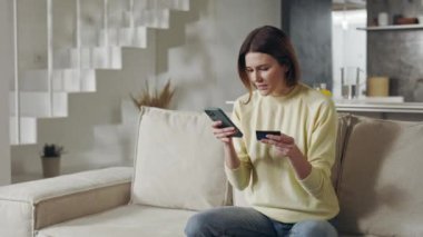 Banka kartı ve cep telefonu olan bir kadın internetten mal alıyor.