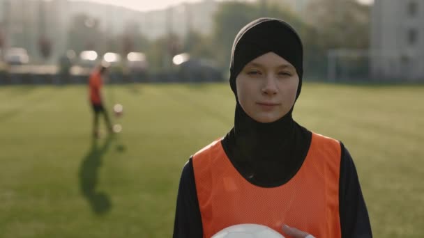 Woman in hijab holding soccer ball and looking at camera — Stock Video