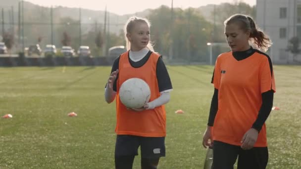 Dos jugadoras de fútbol caminando y hablando después del entrenamiento — Vídeo de stock