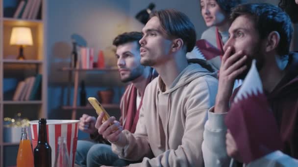 Excited people looking attentively at the device screen and feeling overjoyed while gesturing with fists. Fans feeling blessed of sports betting during football game at home concept. — Vídeo de Stock