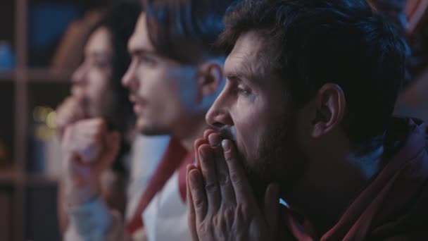 Diverse team of multiracial friends watching soccer together. At the first plan bearded man expressing nervous emotions and awaiting for the goal. Football fans concept. — Video