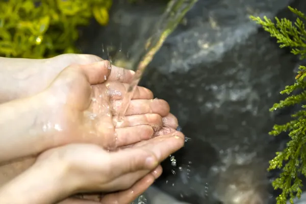 Hands catching clean falling water