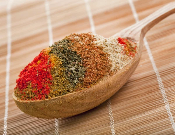 Spice powder mix in a wooden spoon on a bamboo napkin