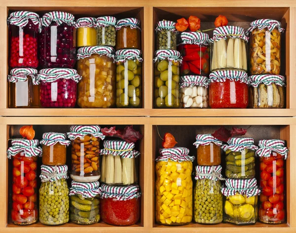 Many glass bottles with preserved food in wooden cabinet Isolated on white background