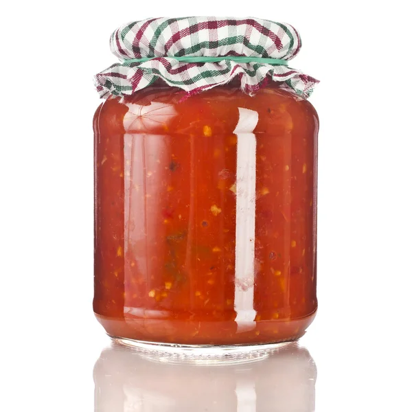 Delicious product of roasted red pepper, tomatoes in glass jar close up isolated on a white background — Stock Image Delicious product of roasted red pepper, tomatoes in glass jar close up isolated on a white background Stock Photo