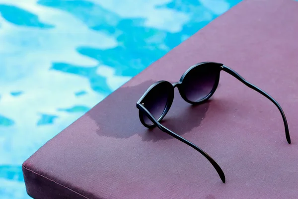 Sunglasses by the swimming pool. — Stock Photo, Image