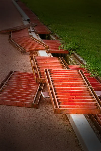 Old iron with grass malfunctioning the drain. — Stock Photo, Image