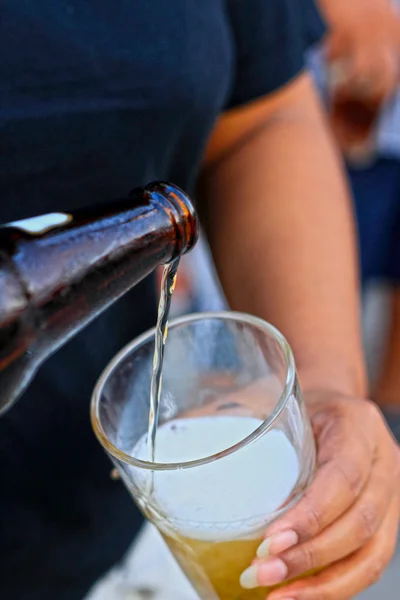 Gazdaság üveg sört nő öntötte egy pohár. — Stock Fotó