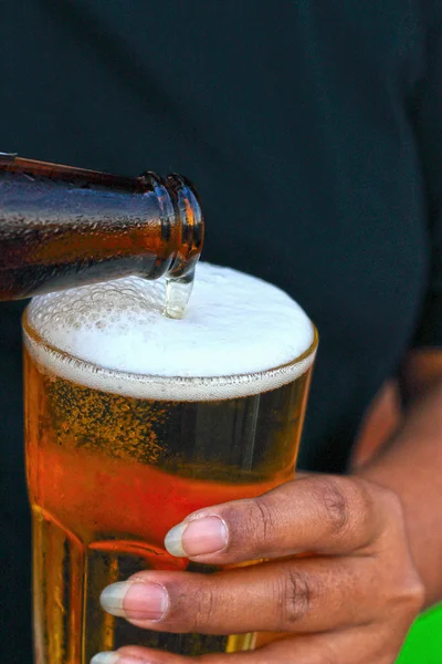 Woman holding bottle of beer poured a glass. — Stock Photo, Image