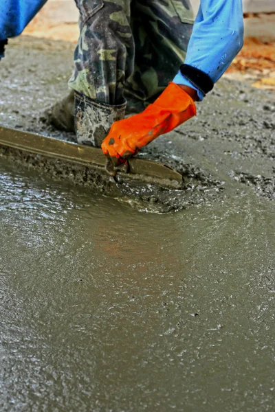 Gieten van concrete mix voor werknemers in de bouw weg. — Stockfoto