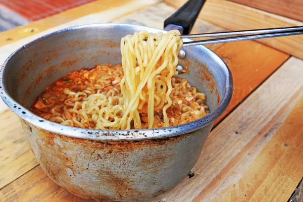 Chopsticks holding asian noodles in pot — Stock Photo, Image