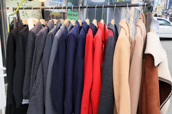 Shop shirts colorful fabric hanging on a rack. — Stock Photo, Image