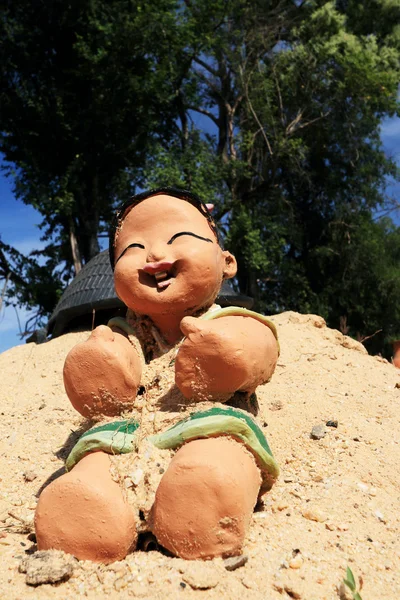 Estátua de boneca bebê na areia . — Fotografia de Stock