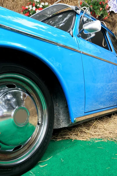 老式汽车的一部分蓝色，有一堆稻草. — 图库照片